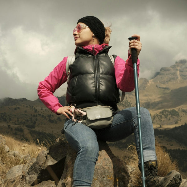 Person hiking in a mountainous area with a cloudy sky